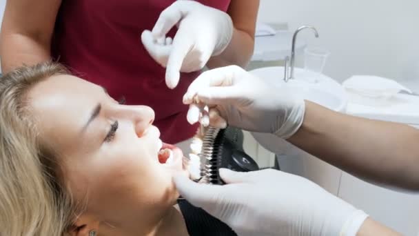 Imagens 4k do dentista verificando a cor dos dentes dos pacientes antes do procedimento de clareamento — Vídeo de Stock