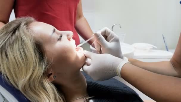 Imagens de close-up 4k do dentista removendo o batom com algodão dos dentes dos pacientes — Vídeo de Stock