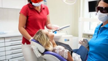 hastalar dişlerde fotopolimer sertleştirme için diş hekimi asistanı holding kür Uv lambası 4 k video