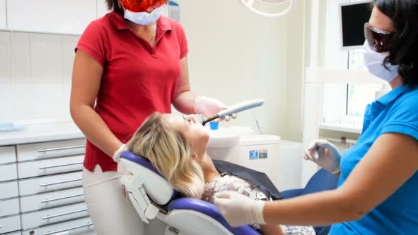 4 k βίντεο οδοντίατρος Βοηθός εκμετάλλευση πολυμερισμού Uv λαμπτήρα για σκλήρυνση Φωτοπολυμερικές στα δόντια των ασθενών — Αρχείο Βίντεο