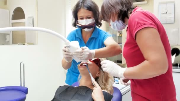 Imagens 4k de dentista ajustando e ligando a lâmpada para clareamento dos dentes — Vídeo de Stock