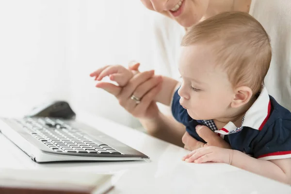 Closeup image of little baby boy looking at keyboard in office — Stock Photo, Image