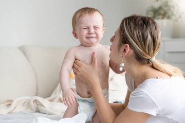 Sevecen ve Ağlayan bebek oğlu yatıştırıcı güzel genç anne
