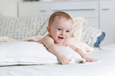 Büyük yastık yatakta yatan çok güzel 9 aylık bebek çocuk portresi
