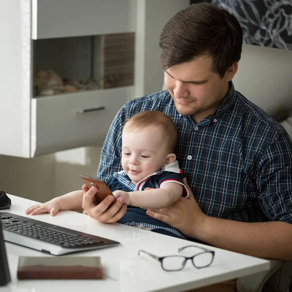 Chłopiec Cute dziecko siedzi na kolanach ojców i pisania na klawiaturze komputera — Zdjęcie stockowe