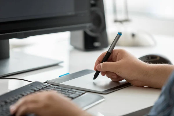 Closeup image of male graphic designer holding stylus and drawing on graphic tablet — Stock Photo, Image