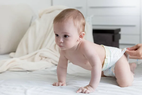 귀여운 9 개월 된 아기 기저귀 침대에 크롤 링 — 스톡 사진
