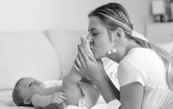 Schwarz-Weiß-Porträt einer jungen Mutter, die ihre kleinen Söhne küsst — Stockfoto