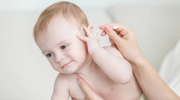 Anne temizlik bebek oğulları kulakları pamuk bez ile portre fotoğrafı — Stok fotoğraf