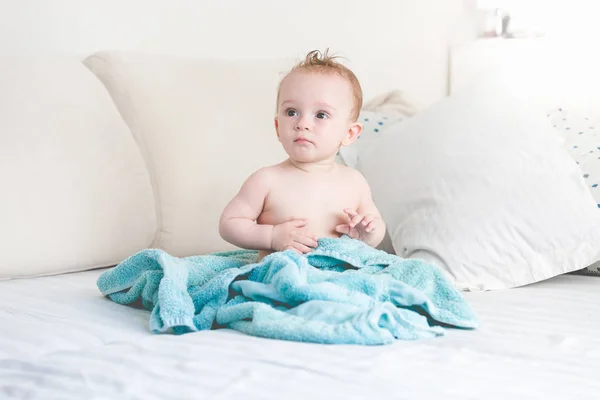 Adorável menino de 9 meses sentado na cama após a lavagem no banho — Fotografia de Stock