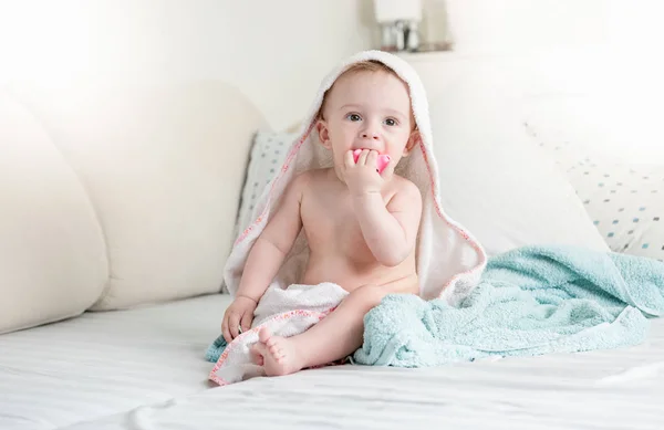 可爱的小男孩穿着毛巾, 坐在床上洗澡后玩玩具 — 图库照片