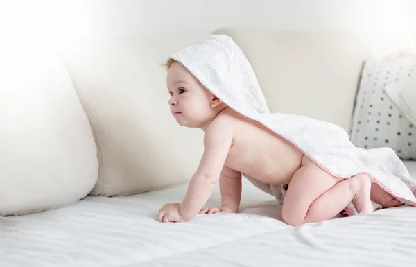 귀여운 아기 침대에 크롤 링 하는 머리에 후드와 함께 수건으로 — 스톡 사진
