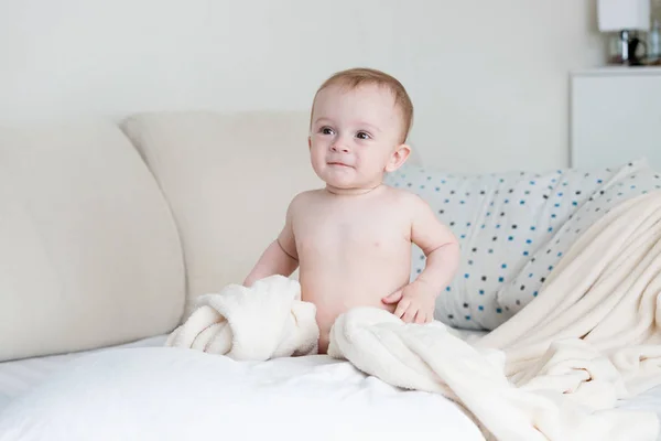Söt baby pojke sitter på stora sängen i sovrummet — Stockfoto