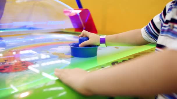 Close-up 4k video van kleine jongen hebben plezier in pretpark en spelen in air hockey — Stockvideo