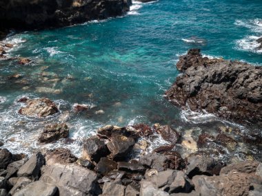 Keskin kayalıklarda yuvarlanan ve kırılan okyanus dalgalarının güzel bir görüntüsü.