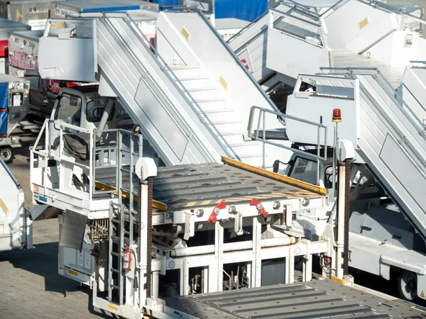 Foto de grande serviço de terra estacionamento de carrinhos de bagagem e escadas no aeroporto — Fotografia de Stock