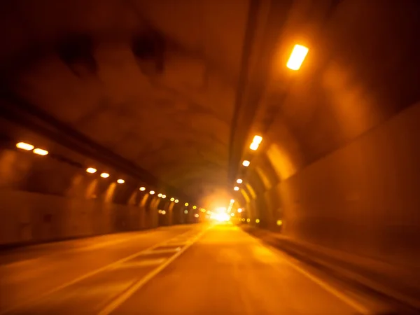 Immagine sfocata dell'auto che cavalca nel tunnel buio attraverso la montagna — Foto Stock