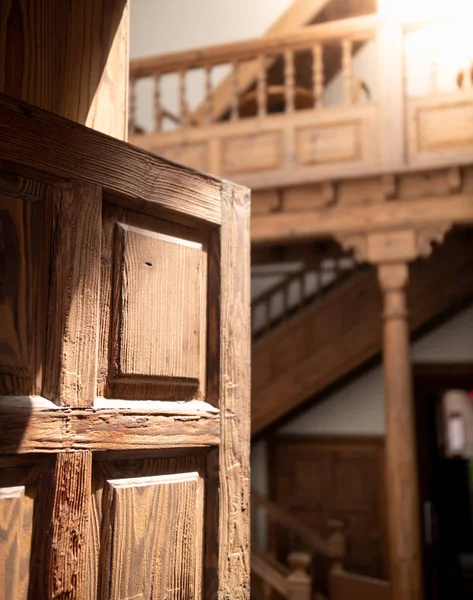 Detailní záběr na staré tradiční dřevěné dveře vedoucí do domu dvorku s dřevěnou hvězdicí a balkónem — Stock fotografie