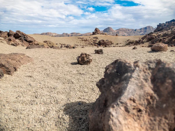 Κοντινή εικόνα μαύρων βράχων και κομματιών κρύας λάβας στην έρημο ενάντια στο ψηλό ηφαίστειο. Ηφαίστειο Τέιντ, Τενερίφη — Φωτογραφία Αρχείου