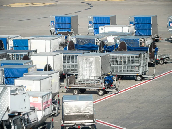Kép sok poggyász és rakomány szállító kocsik repülőtéri földi szolgáltatás parkoló — Stock Fotó