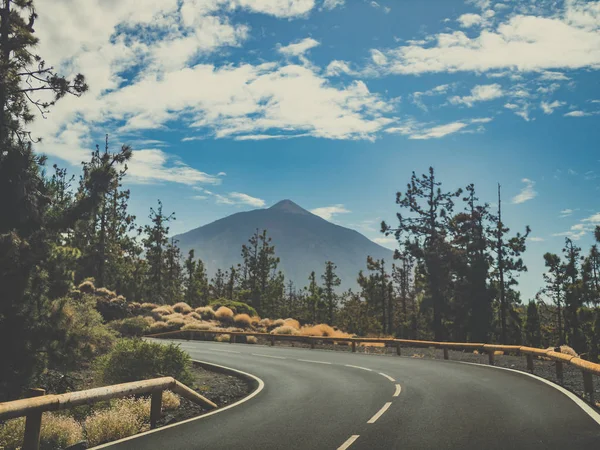 Тонированное изображение резкого поворота дороги в горах и удивительный вид на вулкан Тейде, Тенерифе, Канарский остров — стоковое фото
