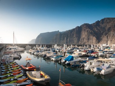 Los Gigantes, Tenerife adasındaki limanda demirlemiş bir sürü tekne, gemi ve yatın tonlu görüntüsü.