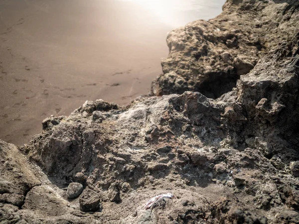 Imagen macro de acantilados afilados y rocas en la playa del océano arenoso —  Fotos de Stock