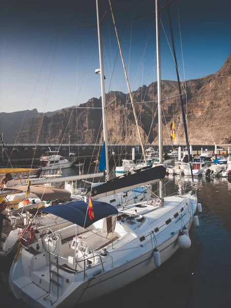 Toned kép drága jachtok kikötve a kikötőben ellen magas sziklák és hegyek — Stock Fotó