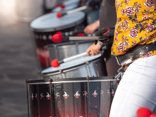 Крупный план уличных музыкантов, играющих на барабанах с барабанными палочками во время уличного преобразования — стоковое фото