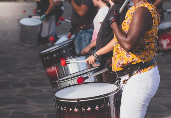 Toned image of musicians playing on drums while showing performance on city street — Stock Photo, Image