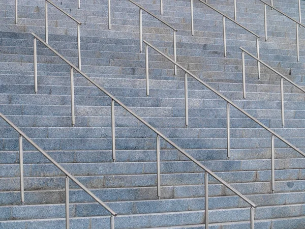 Αφηρημένη εικόνα από μεγάλες πέτρινες σκάλες με μεταλλικές χειρολαβές. — Φωτογραφία Αρχείου