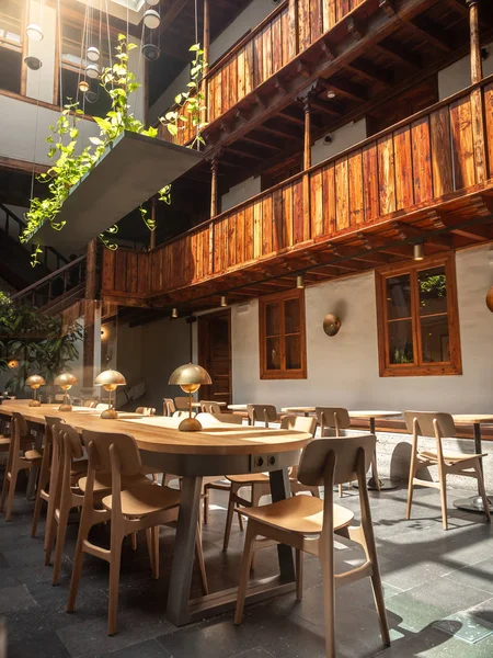 Красивый образ длинного деревянного стола и стульев во внутреннем дворе современного кафе — стоковое фото