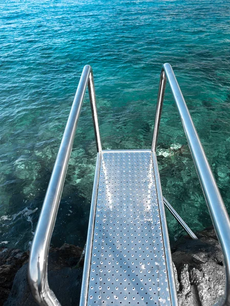 Beautiful image of metail handsrails and stairs going in blue ocean water — Stock Photo, Image