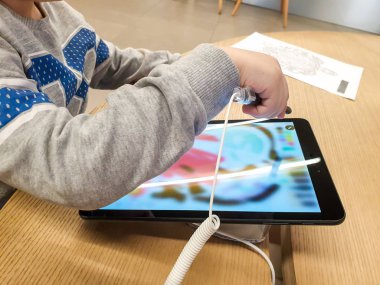 Küçük çocuğun dijital tablet bilgisayarda resim çizmek için stilus kalem kullandığının yakın plan görüntüsü