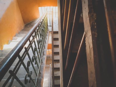 Avrupa 'daki eski bir binada metal tırabzanlar olan eski ahşap merdivenlerin tonlu görüntüsü.