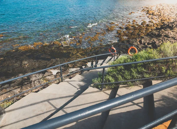 Imagen tonificada de escaleras curvas con pasamanos en la costa del océano con acantilados afilados —  Fotos de Stock