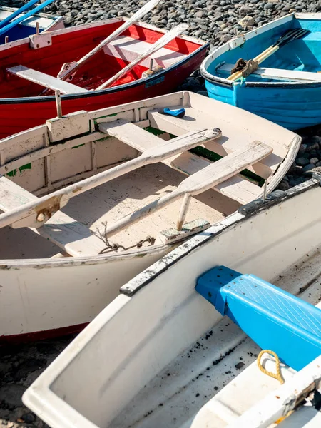 Closeup image of colorful wooden rowing boats lying on the rocks at sea beach — Stock Photo, Image