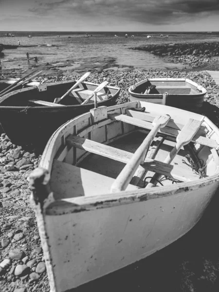 Black and white image of old wooden rowing boats on the sea beach at small spanish town on Tenerife — Stock Photo, Image