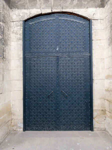 Крупный план большой металлической двери в старых каменных стенах замка — стоковое фото