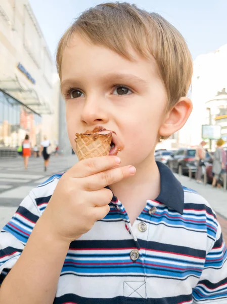 Portrait of little boy with dirty mouth eating chocolate ice cream on street — Stock Photo, Image