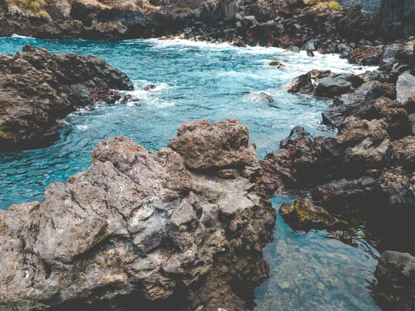 Imagem tonificada da lagoa oceânica com água azul-turquesa rodeada por penhascos afiados e rochas vulcânicas — Fotografia de Stock