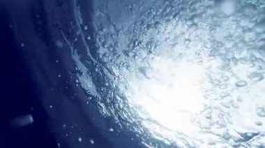 Güneş 'e doğru yüzen dalgıçlar tarafından salınan birçok hava kabarcığının güzel soyut arkaplanı