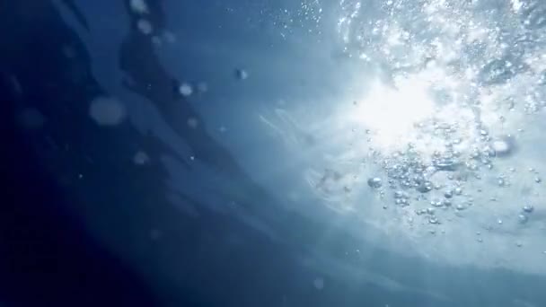 Pohled z mořského dna na na sluneční paprsky, vlny a plovoucí vzduchové bubliny — Stock video