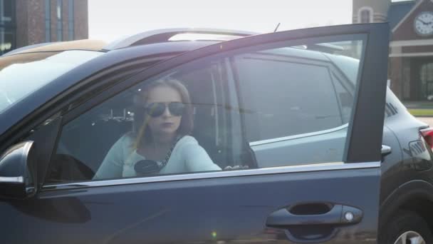4k vídeo de bela mulher elegante na saia saindo de seu carro e andando com xícara de café no estacionamento — Vídeo de Stock