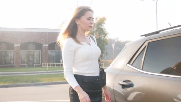 4k video de hermosa mujer sexy sentada en el coche y besando a su novio esperando en el estacionamiento — Vídeo de stock