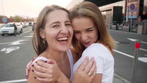 4k video de dos niñas felices riendo frinds abrazando y abrazando mientras se hace selfie en el estacionamiento y centro comercial — Vídeo de stock