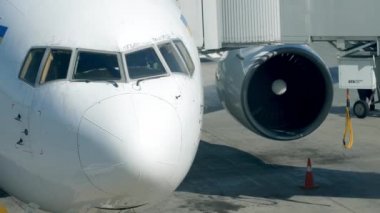 4k video of parked airplane near gate in airport. Passengers boarding on plane
