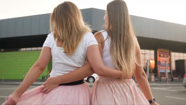 4kビデオの陽気で幸せな大人の双子の妹抱擁しながら歩いてショッピングモール — ストック動画