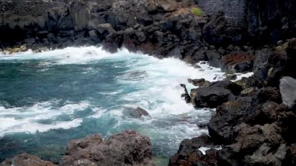 4k lassított felvétel nagy óceán hullámok gördülő és törés fekete sziklák és sziklák a tengerparton — Stock videók