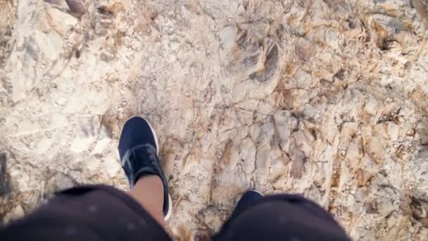 4k POV video de pies masculinos en zapatillas de deporte caminando por el acantilado. Hombre descendiendo sobre una montaña empinada y rocas — Vídeos de Stock